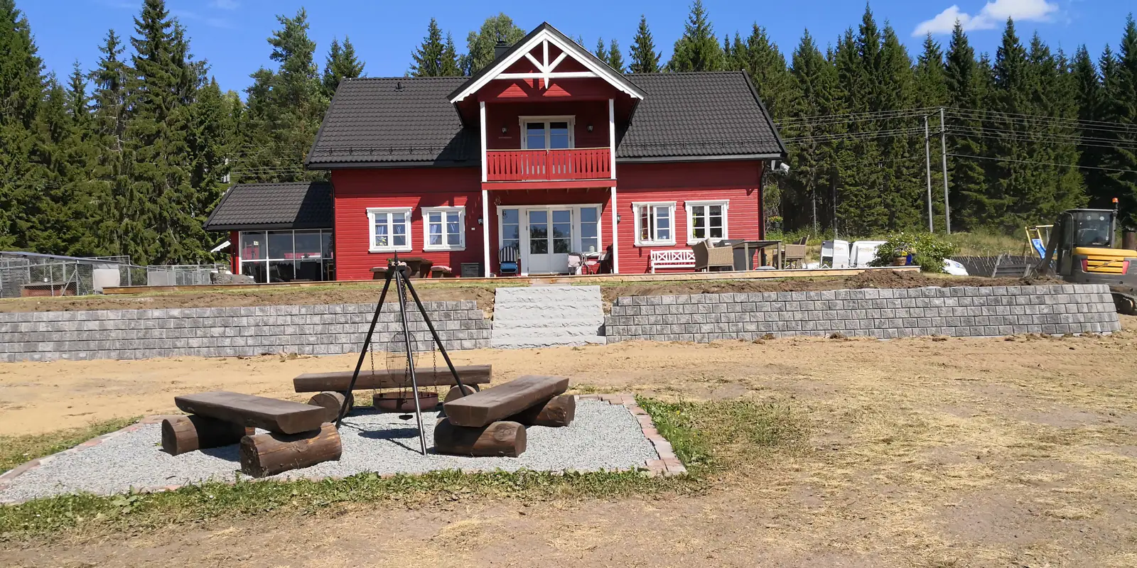 Støttemur foran rødt hus